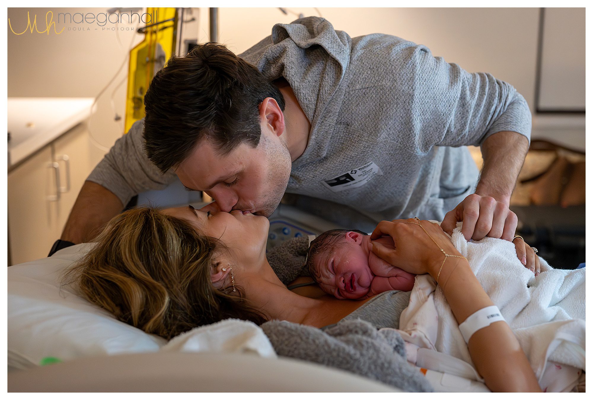 Atlanta doula photographing dad kissing mom after birth. 
