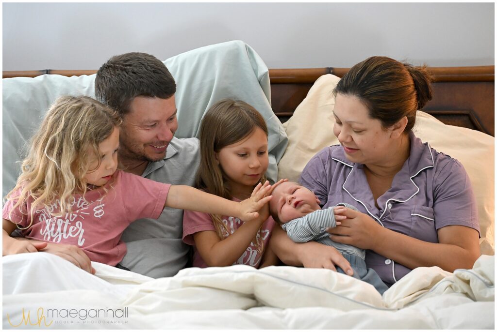 family cuddles in bed after succesful ECV birth
